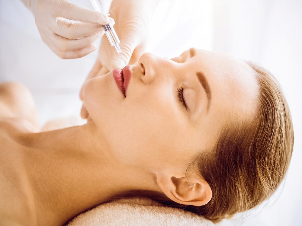  A woman receiving a lip filler procedure from a doctor.