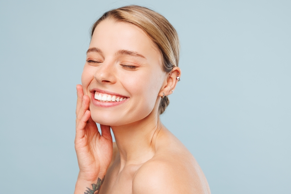 `alt="A woman with a radiant smile and beautiful skin."`