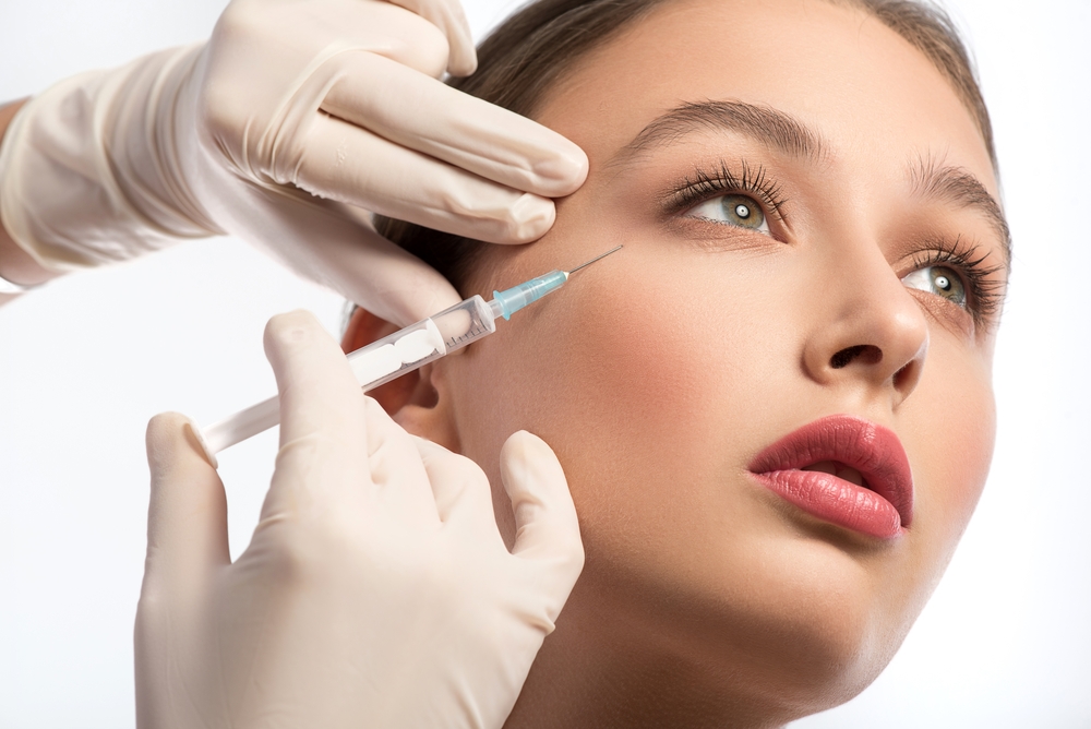 A woman receiving Botox injections at the corners of her eyes