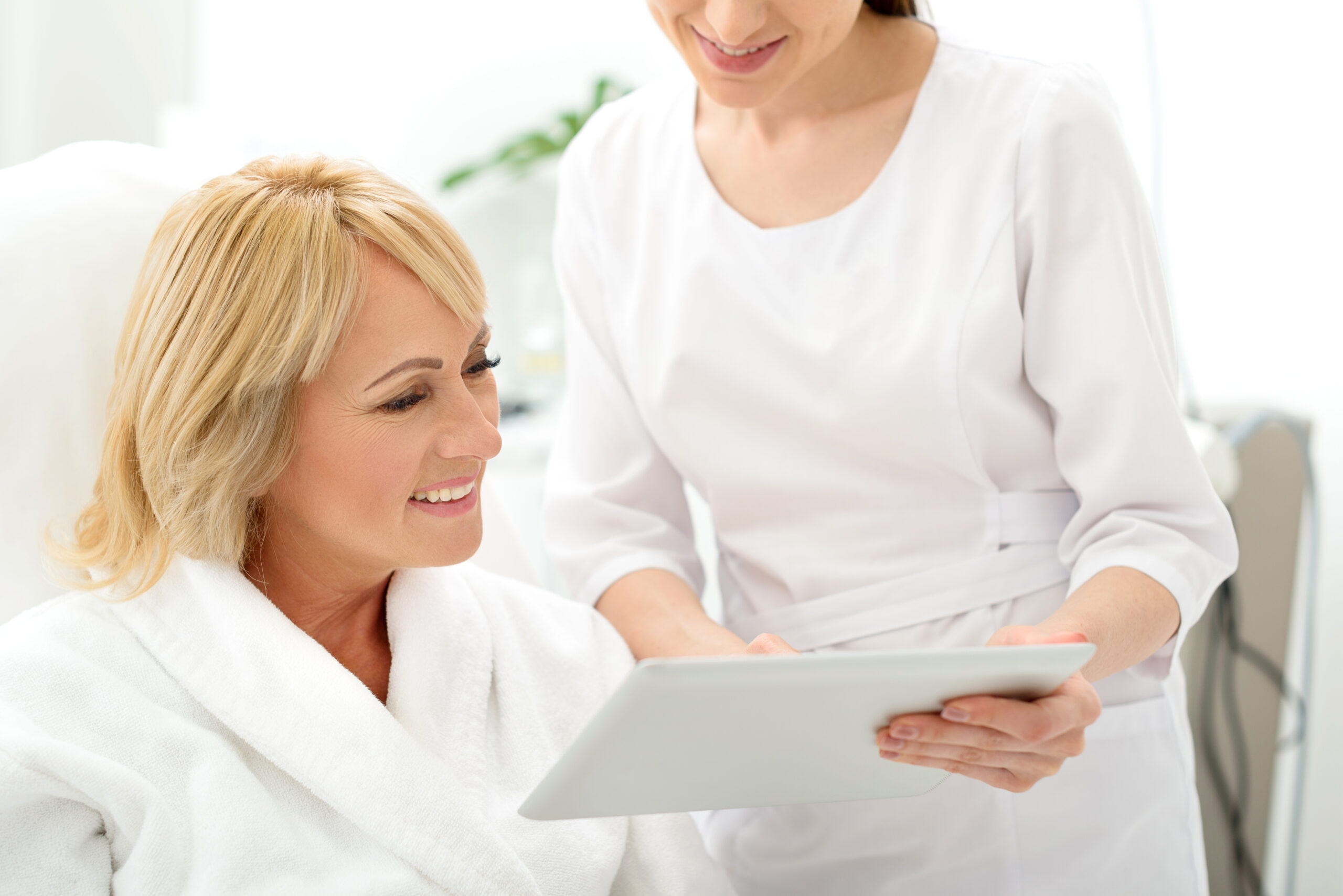 `alt="A woman receiving a consultation at a cosmetic dermatology clinic."`