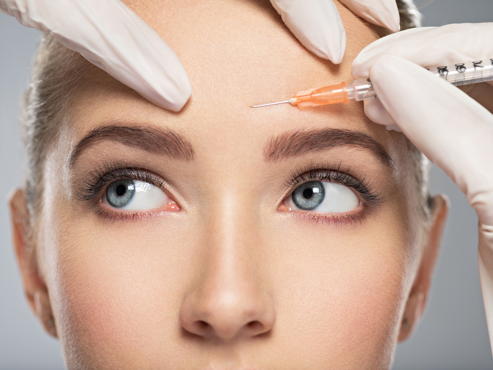 A woman receiving Botox injections in her forehead to treat hyperhidrosis