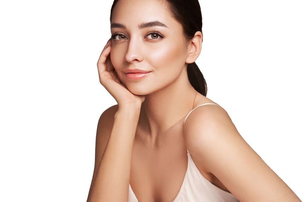 Woman holding her cheek to illustrate a lifted and youthful facial appearance.