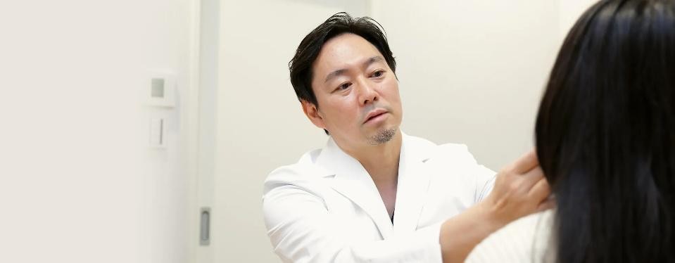 Dr. Takashi Nakao examining a patient at NAKAO PLASTIC SURGERY