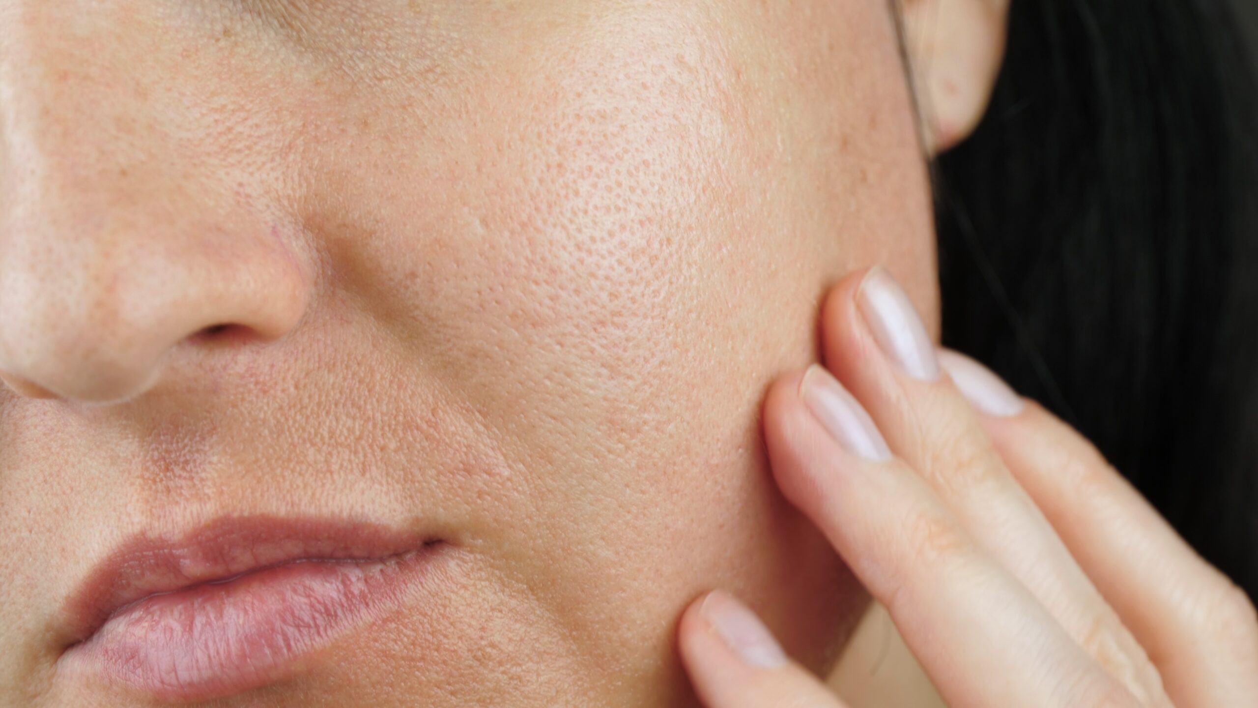 Woman examining her skin and pores