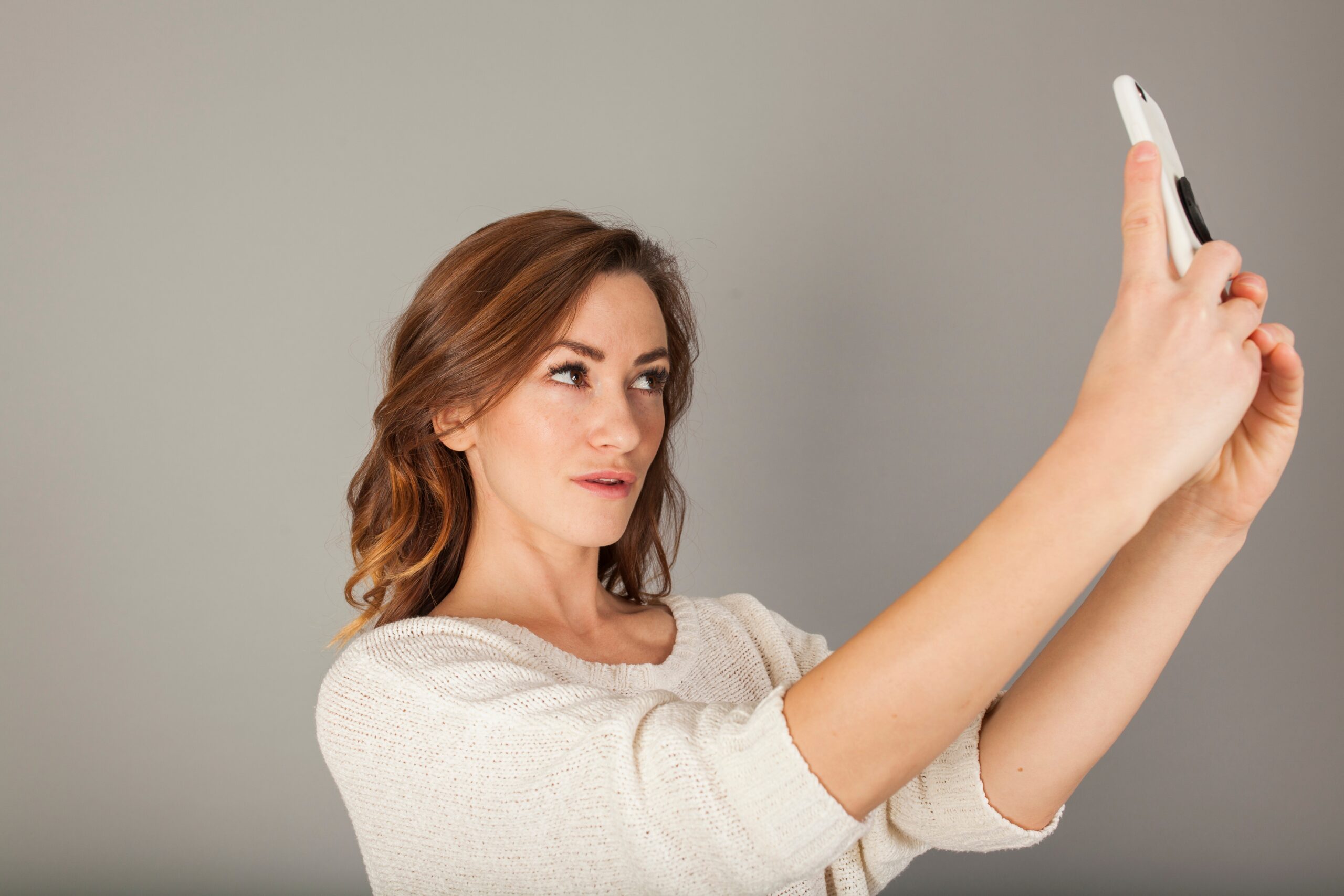 Woman looking at her smartphone scaled