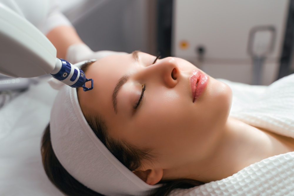 A woman receiving laser treatment at a cosmetic clinic