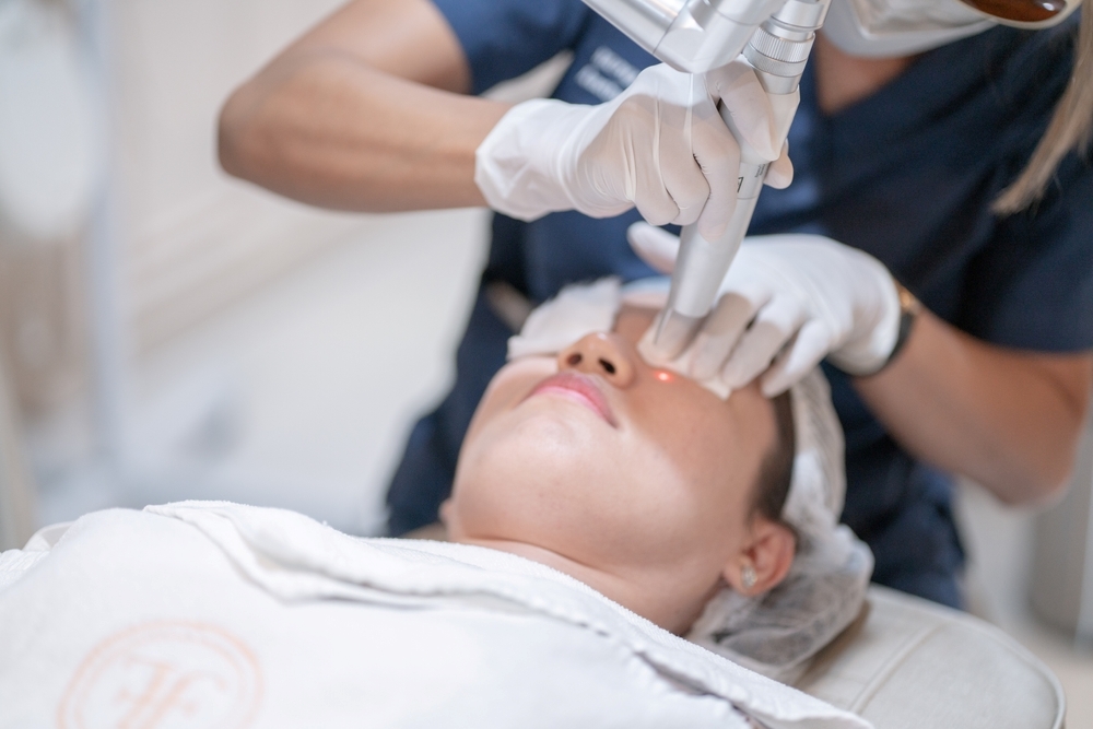 A woman receiving laser treatment at a cosmetic clinic