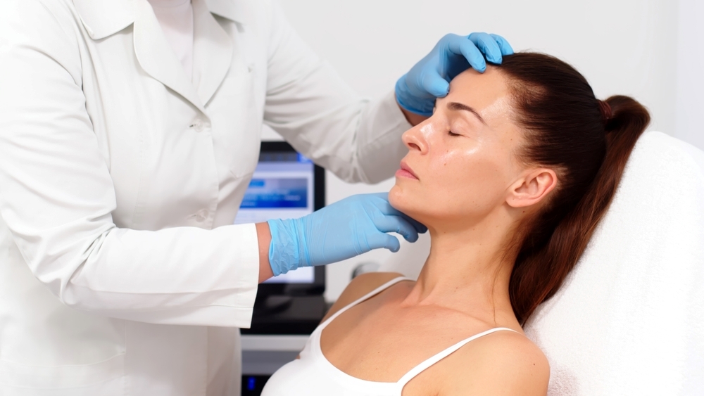 A patient having a pre-surgical aesthetic consultation with a plastic surgeon in Japan, discussing facial structure and treatment planning. 和訳