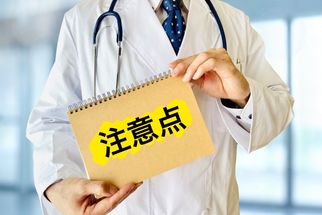 注意点を持つ白衣の男性 美容内服は保険適用?処方の境界線と自費で続けるときの注意点|NERO DOCTOR / BEAUTY(美容医療)