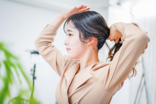 髪をまとめる女性　かぎ鼻（鍵鼻・鉤鼻）とは？セルフケアから美容医療まで美しい鼻筋を目指す方法を解説｜NERO DOCTOR / BEAUTY（美容医療）