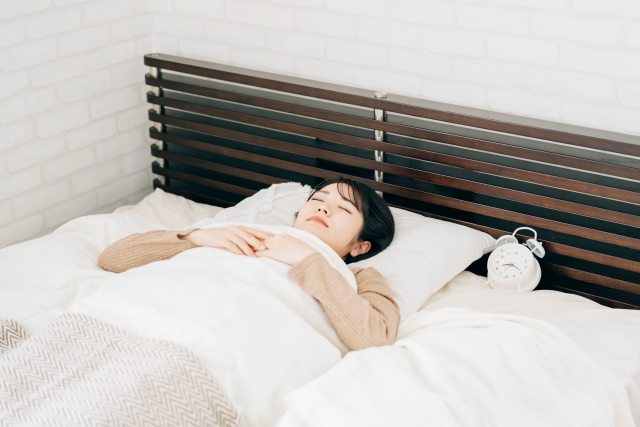 ベッドで眠る女性 脂肪豊胸ダウンタイムの症状や経過は?軽減のためにできることを解説|NERO DOCTOR / BEAUTY(美容医療)