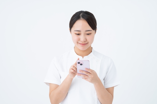 スマホを操作するスタッフ 美容看護師向けセミナーがブーム!“学ぶナース” 急増の背景と現場の変化とは?|NERO DOCTOR / BEAUTY(美容医療)