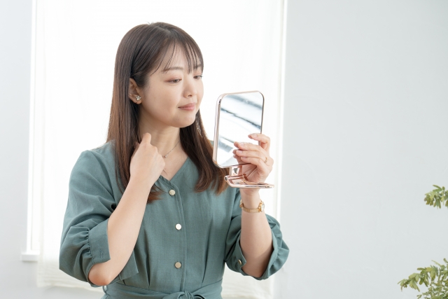 鏡を見る女性 顔たるみで即効性のある50代向けの治療は?施術の選び方と注意点|NERO DOCTOR / BEAUTY(美容医療)