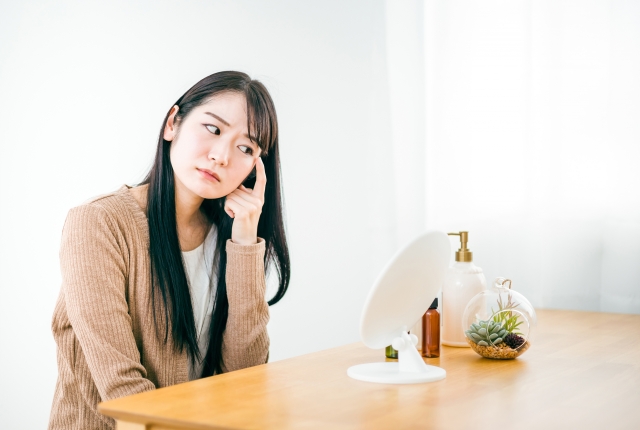 鏡を見て悩む女性　埋没法10年以上の癒着どう考える？再手術を考えるタイミングとは｜NERO DOCTOR / BEAUTY（美容医療）