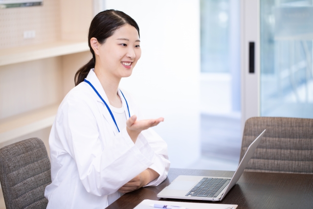 説明する白衣の女性 眼瞼下垂は保険適用になる?基準・費用・自由診療との違い|NERO DOCTOR / BEAUTY(美容医療)