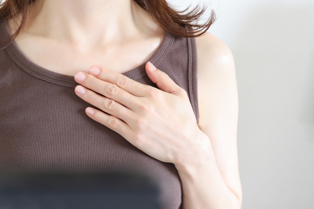 胸に手を当てる女性 シリコン豊胸が初めての人へ|選び方のヒントになる基礎知識&他の施術との比較|NERO DOCTOR / BEAUTY(美容医療)