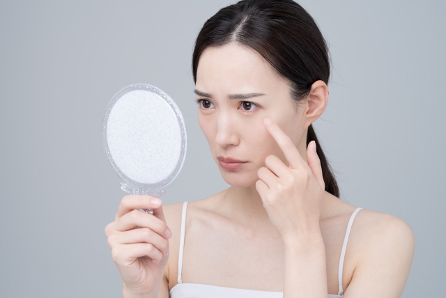 鏡を見て悩む女性　こめかみリフトで目指せる変化とは？他のリフト施術との違いも｜NERO DOCTOR / BEAUTY（美容医療）