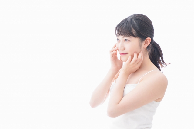 頬に手を当てて微笑む女性 鼻プロテーゼで後悔しないために|よくある失敗例と事前にできる対策|NERO DOCTOR / BEAUTY(美容医療)