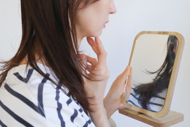 鏡を見る女性　プルリアルのダウンタイムは？赤み・腫れ・遅れて出る炎症の注意点と予定の立て方を解説｜NERO DOCTOR / BEAUTY（美容医療）
