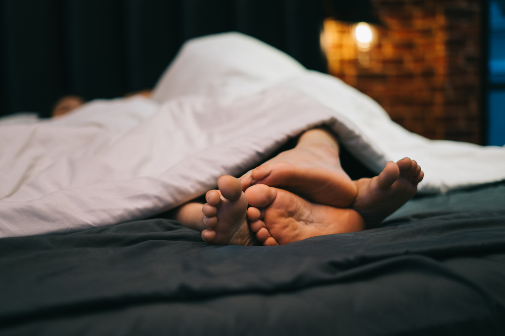 ベッドで寝る男女の足元