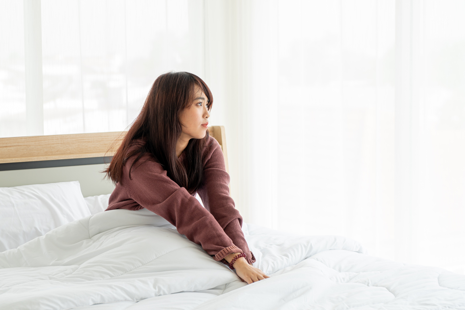 ベッドで起き上がっている女性