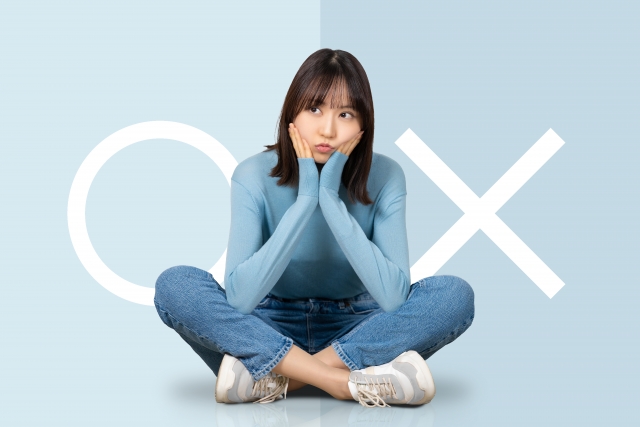 おなかの脂肪吸引が向いている人と向いていない人のイメージ（○×のプラカードを持つ女性）