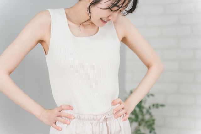 おなかの脂肪吸引後の仕上がりやダウンタイム経過のイメージ（ウエストに手を当てる女性）