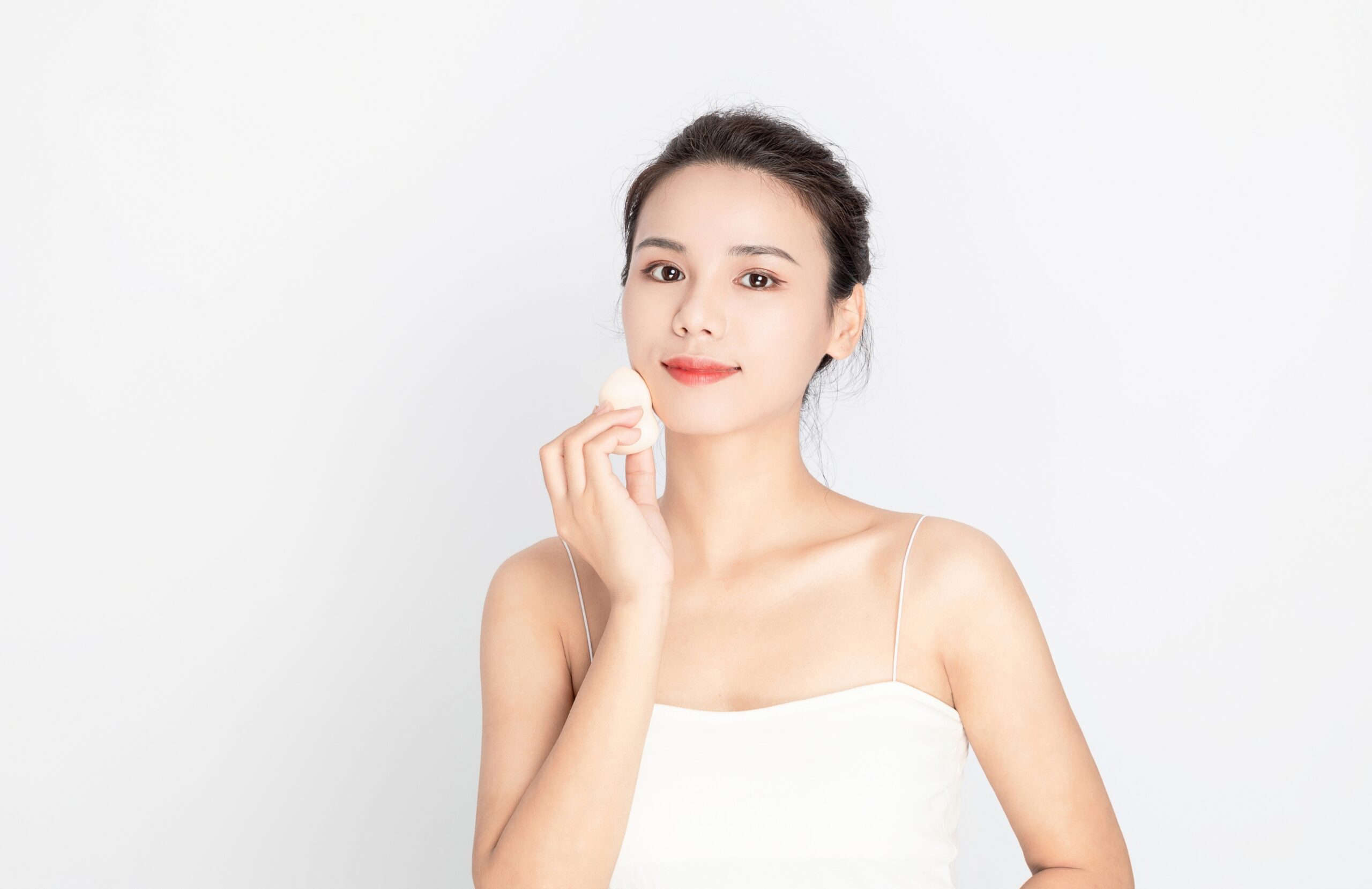 メイク道具を持つ鼻のきれいな女性